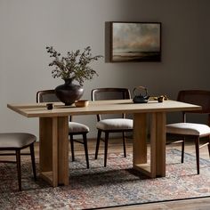 a wooden table with chairs around it and a vase filled with flowers on the table