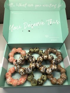 a box filled with assorted donuts sitting on top of a table next to a sign that says, if what are you waiting for?