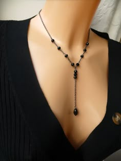 Stylish gunmetal black lariat style necklace featuring black crystal beads. This listing is for a gunmetal chain and black crystal lariat necklace. It features a single chain necklace adorned by black faceted crystals. The necklace closes with a lobster clasp with extender chain attached. The necklace has a lariat comprising gunmetal chain, 3 x faceted black crystal beads and completed with a faceted teardrop bead. NECKLACE LENGTH - 16" plus 1=2" extender LARIAT - 3" round black crystals - 4mm teardrop crystal - 10mm The necklace comes boxed ready for gifting. Please contact me if you have any questions. Thanks for looking. To view other necklaces, please click here http://www.etsy.com/uk/shop/GemmaJolee?section_id=13763885 To view other items in the shop click here http://www.etsy.com/uk/ Black Necklace Elegant, Diy Crystal Jewelry, Black Bead Chains, Bead Necklace Ideas, Black Beads Necklace, Chain Outfit, Black Crystal Necklace, Gothic Necklaces, Lariat Style Necklace