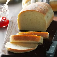 a loaf of bread sitting on top of a cutting board next to a knife and butter