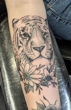 a tiger and flowers tattoo on the arm