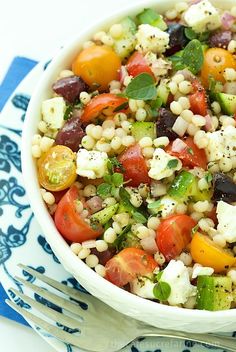 a white bowl filled with lots of different types of food on top of a blue and white napkin