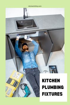 a man laying on the ground under a kitchen sink next to tools and other items