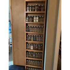 an open pantry door with jars and cans on it