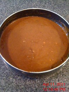 a metal pan filled with brown liquid on top of a granite countertop next to a knife