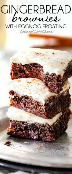 three brownies with white frosting stacked on top of each other in front of the words, gingerbread brownies with eggnog frosting