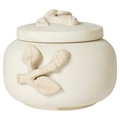 a white crock with spoons and bones on it