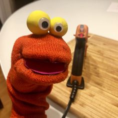 a close up of a stuffed animal on a table with a hair dryer in the background