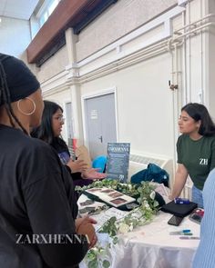 several people standing around a table with flowers on it and signs in front of them