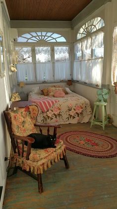 a room with a bed, chair and rugs on the floor in front of it