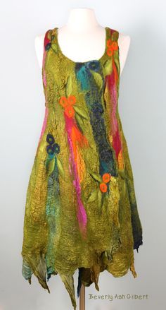 a woman's green dress with colorful flowers on the front and back, sitting on a mannequin