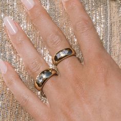 a woman's hand with two rings on it