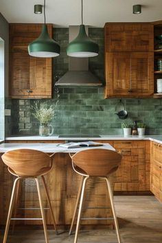 two wooden stools sit at the center of a kitchen island with green tile backsplash