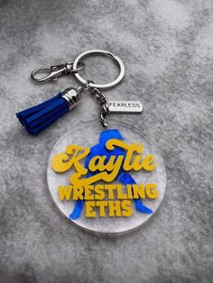 a keychain with the words kayte wrestling on it and a tassel