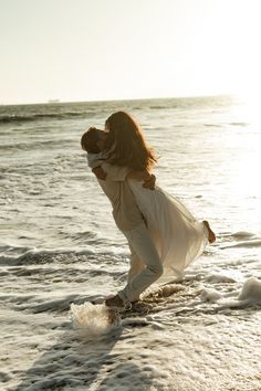 a woman is walking on the beach with her arms around another woman