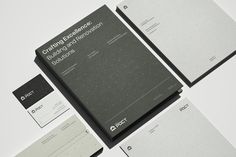 various stationery items are displayed on a white surface with black and grey accents, including notebooks