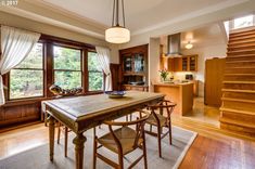 a wooden table sitting in the middle of a living room next to a stair case