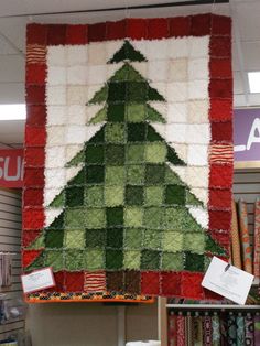 a christmas tree quilt hanging in a store