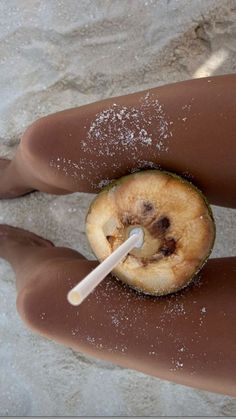 a person's legs covered in white powder and an apple with a straw sticking out of it