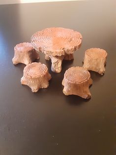 four pieces of carved wood sitting on top of a black table next to each other