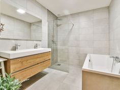 a bathroom with a sink, bathtub and shower stall in it's corner