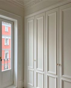 an empty room with white cupboards and windows