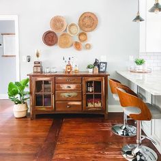 a room with wooden floors and lots of plates hanging on the wall above the bar