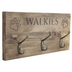 a wooden sign with hooks on it that says,'walkies'and paw prints