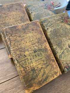 three old books sitting on top of a wooden table