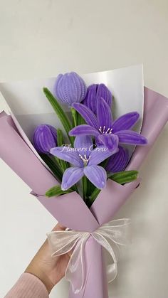 a bouquet of purple flowers is being held by a person