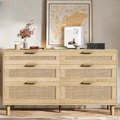 a wooden dresser with drawers and pictures on top