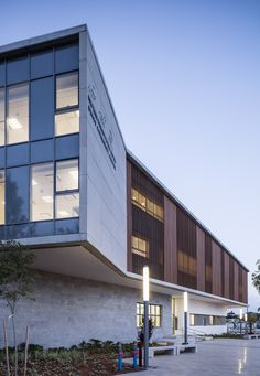 a building with many windows and lights on the side of it's front entrance