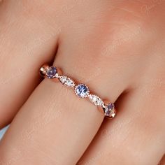 a woman's hand with a diamond and tan sapphire ring on top of her finger