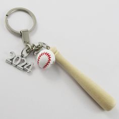 2024 3D Baseball Softball Charm Keyring      Heavy duty, solid keychain with 3D wood bat and ball and alloy metal 2024 charm pendant.        Bulk discounts for Team sets are available, message your requirements          Approx. Measurements: Year Tag 23mm x 12mm / Bat 75x10mm / Ball 15mm Diameter   Keyring Split Ring : 30mm diameter   Total Length : 150mm Bat Ball, Bat And Ball, Wood Bat, Softball Bat, Sports Coach, Charm Keychain, Baseball Softball, Sports Gifts, Split Ring