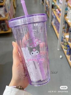 a person holding up a purple cup in a store