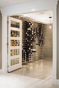 a wine cellar filled with lots of bottles next to a doorway that leads into another room