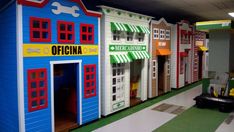 a row of brightly colored wooden toy houses on display in a store or playroom