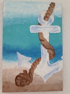 a painting of an anchor and rope on the beach