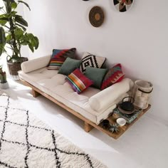 a living room with a white couch and lots of pillows on the back of it