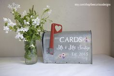 a mailbox and vase with flowers in it