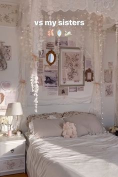 a white bed sitting in a bedroom next to a wall with pictures on the walls