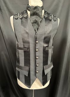 "This is a stunning black heavy suiting fabric waist coat.It is fully lined .It has wide stripes. It has 4 pockets and adjustable back and has buckles detail on front and back shoulder . It has gunmetal buttons. It comes with a black brocade cravat . Chest measurement is XL approx 44/46.  ML chest 40/42  Please refer to measurement in photos.  Length front approx 24\". Adjustable waist . High quality well made Makes a stunning steampunk gentleman's outfit! Thank you for looking" Black Gothic Vest For Alternative Fashion, Party Vest With Buttons In Black, Black Party Vest With Buttons, Black Vest For Halloween Costume, Steampunk Style Sleeveless Black Vest, Black Sleeveless Steampunk Vest, Steampunk Black Sleeveless Vest, Black Steampunk Sleeveless Vest, Black Gothic Costume Vest