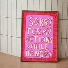 a pink and red sign that says sorry for my actions while hangry on the wall