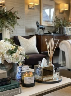 a living room filled with lots of furniture and flowers on top of a coffee table