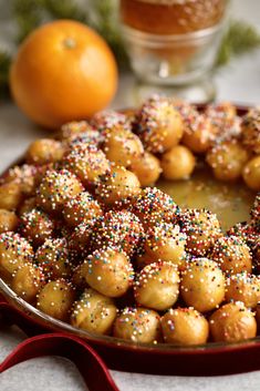 a cake with sprinkles on it sitting in a pan next to an orange