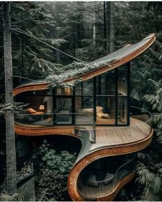 an unusual house in the woods with wooden floors and stairs leading up to it's roof