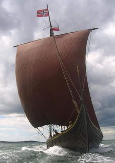 a large brown boat sailing on top of the ocean