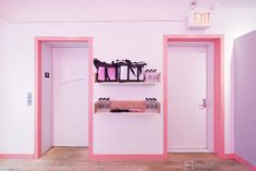 there is a pink room with two doors and some bags on the shelves in it