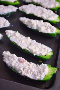 cucumbers filled with cream cheese sitting on a baking sheet