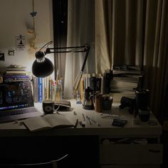 the desk is cluttered with books, papers and a lamp on top of it